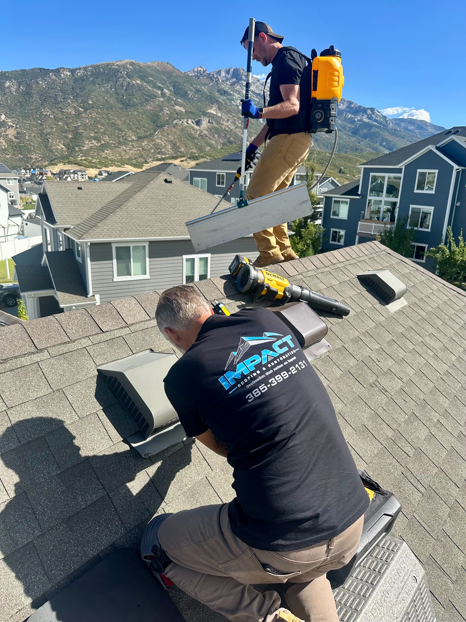 Impact Roofing crew working on a roof along Utah's Wasatch Front